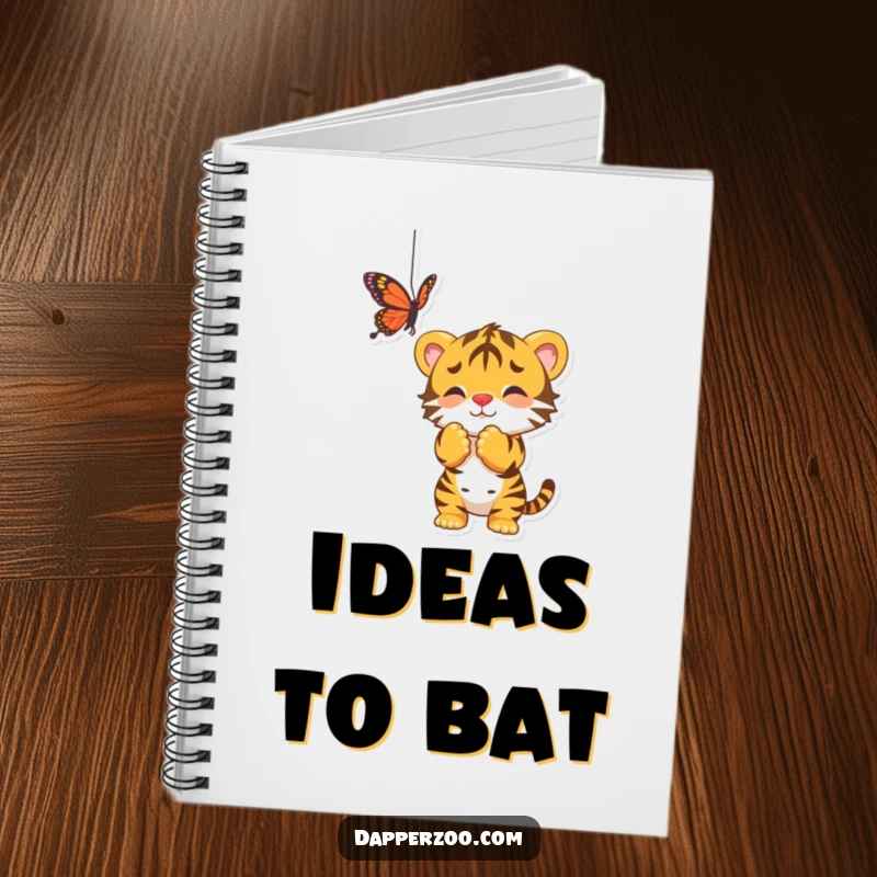 Funny notebook cover featuring a playful tiger cub batting at a dangling butterfly, inspiring creativity and fun.
